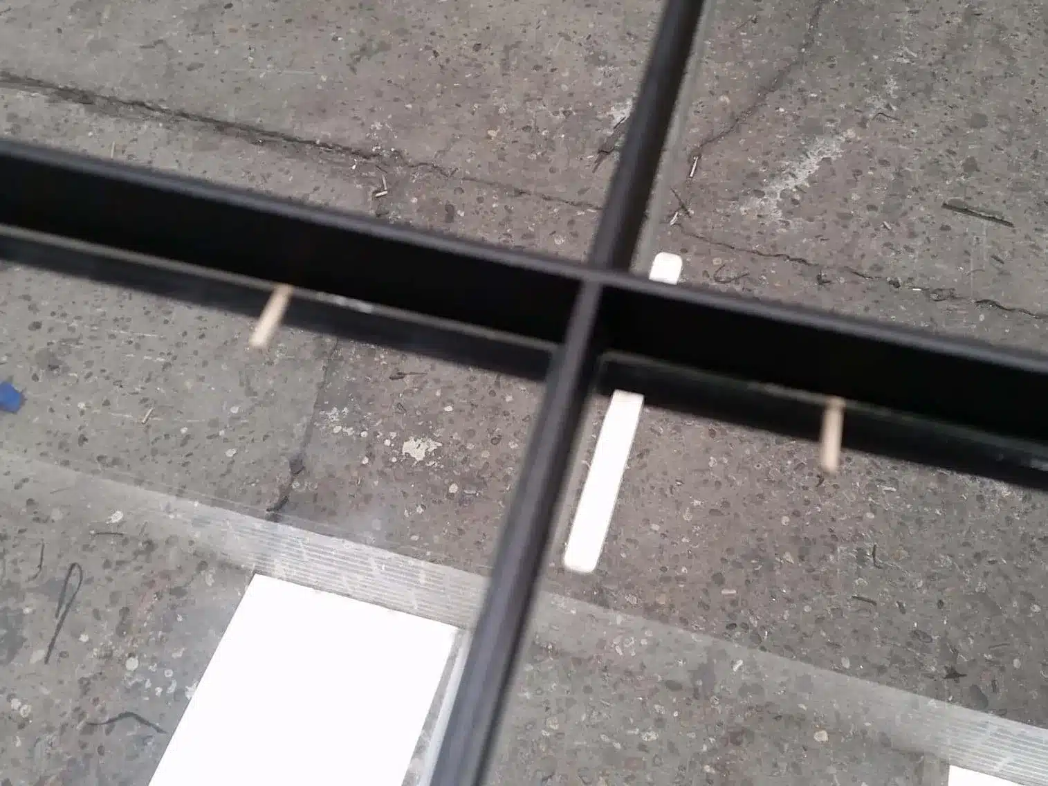 Glasplaat op maat wordt met de hand in een stalen profiel geplaatst