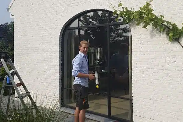 Herstelling van het glas in een stalen boogdeur ter plaatse