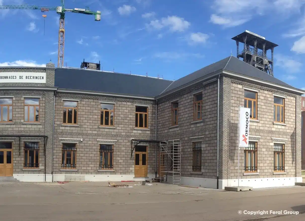 Gerenoveerd kantoorgebouw op de voormalige mijnsite van Beringen, met de schachttoren achter het leien dak.