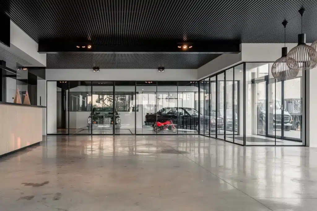 Showroom van een autogarage met zwarte stalen glaswanden rond de kantoren en de autolift.
