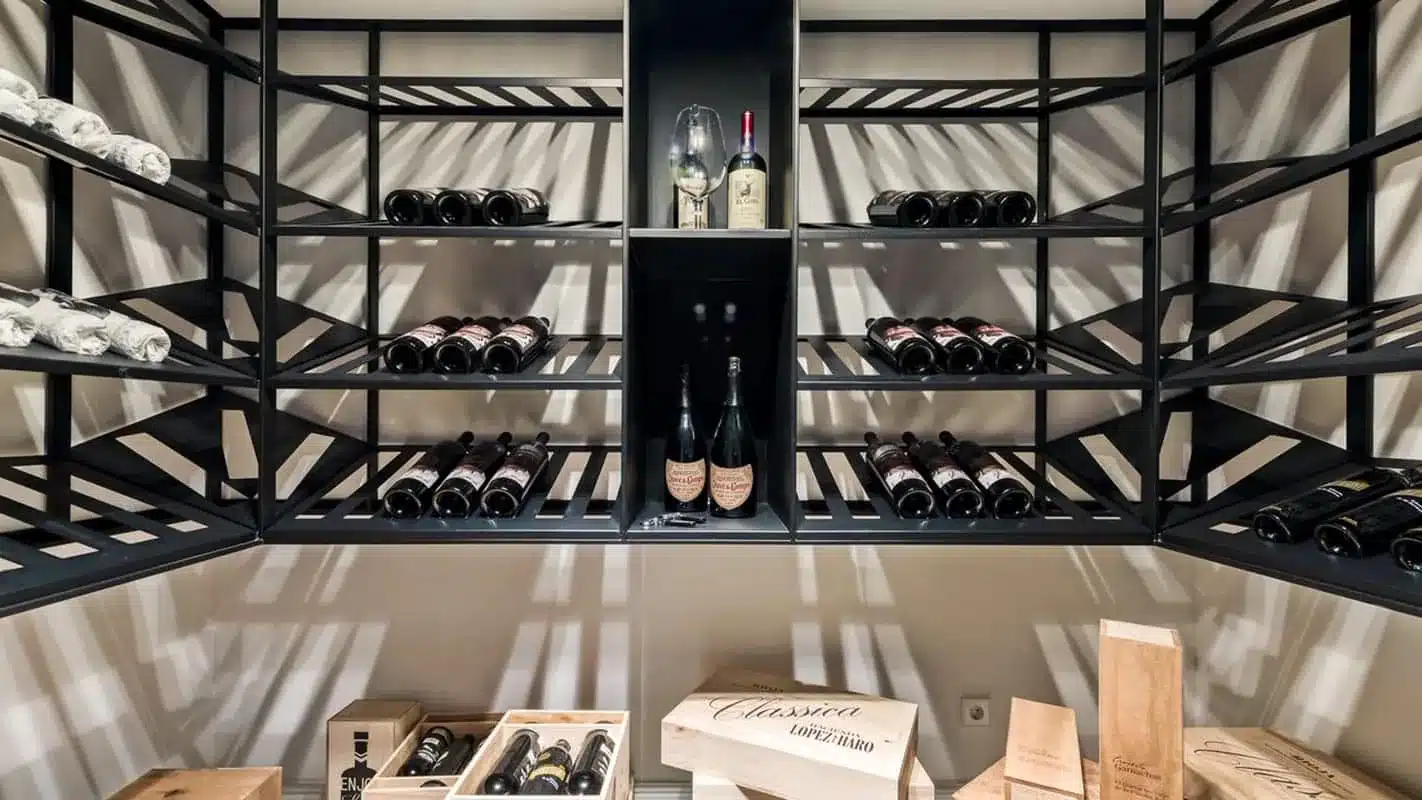 Zwart stalen wijnrek op maat met schuin gelegde flessen en een centrale nis voor champagne.