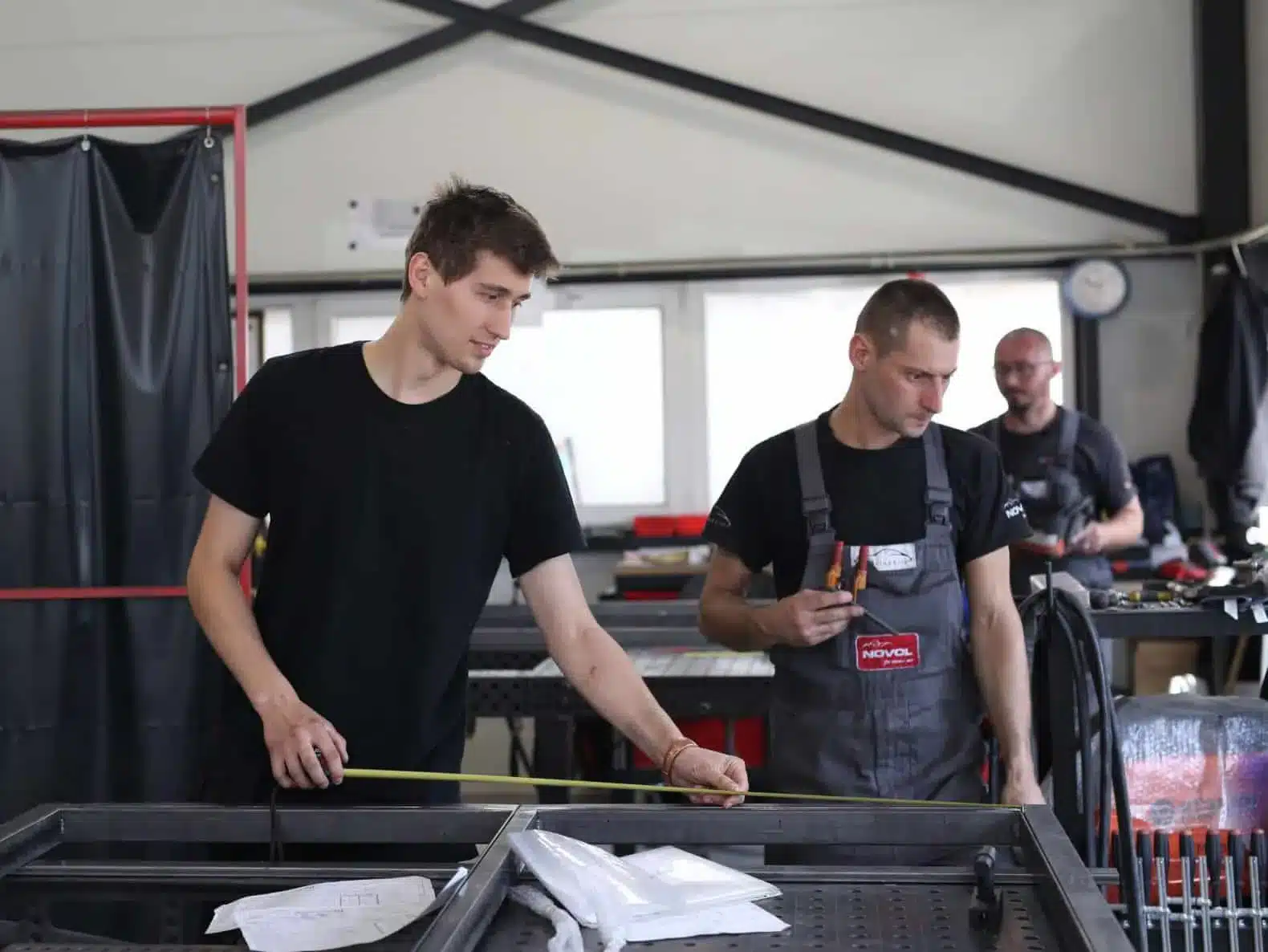 Vakmensen meten een stalen kader na in het atelier